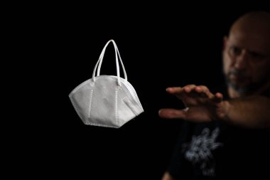 Siyah bir arka plan ve bir adama karşı koruyucu bir maskenin portresi. Salvador, Bahia, Brezilya.