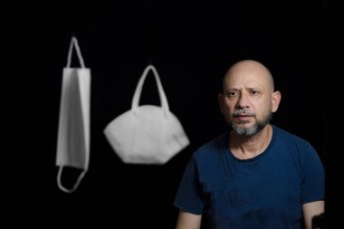 Covid-19 'a karşı iki koruyucu maskenin portresi ve siyah arka plana güvenen bir adam. Salvador, Bahia, Brezilya.