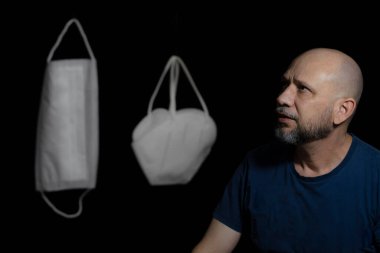 Covid-19 'a karşı iki koruyucu maskenin portresi ve siyah arka plana güvenen bir adam. Salvador, Bahia, Brezilya.