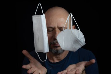 Covid-19 'a karşı iki koruyucu maskenin portresi ve siyah arka plana güvenen bir adam. Salvador, Bahia, Brezilya.