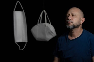 Covid-19 'a karşı iki koruyucu maskenin portresi ve siyah arka plana güvenen bir adam. Salvador, Bahia, Brezilya.