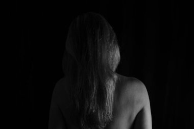 Sırtı kameraya dönük bir kadın stüdyoda siyah arka plana karşı. Salvador, Bahia, Brezilya.