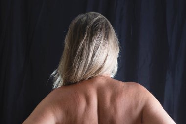 Sırtı kameraya dönük bir kadın stüdyoda siyah arka plana karşı. Salvador, Bahia, Brezilya.