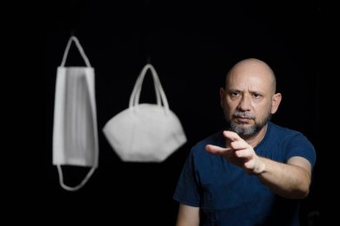 Covid-19 'a karşı iki koruyucu maskenin portresi ve siyah arka plana güvenen bir adam. Salvador, Bahia, Brezilya.