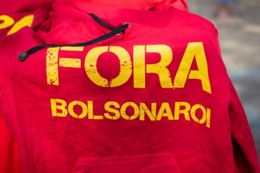 Salvador, Bahia, Brezilya - 02 Ekim 2021: Bahia, Brezilya 'nın başkenti Salvador' da düzenlenen protestoda Fora Bolsonaro 'nun sözlerinin yazılı olduğu afişler ve gömlekler.