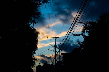 Binaların, evlerin, direklerin, kabloların ve ağaçların gölgesi dramatik günbatımına karşı. Salvador, Bahia, Brezilya.
