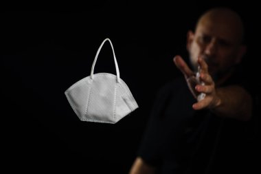 Siyah bir arka plan ve bir adama karşı koruyucu bir maskenin portresi. Salvador, Bahia, Brezilya.