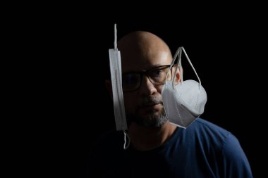 Covid-19 'a karşı iki koruyucu maskenin portresi ve siyah arka plana güvenen bir adam. Salvador, Bahia, Brezilya.