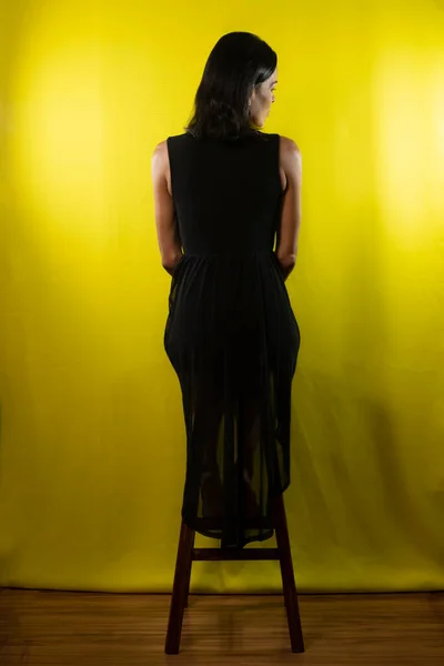 Retrato Modelo Sentado Banco Madera Con Espalda Vestido Negro Sobre — Foto de Stock