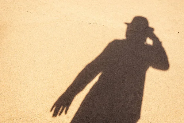 Human shadow on the beach sand. City of Salvador, Bahia, Brazil.