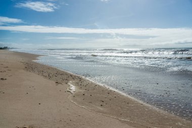 Berrak ve yoğun kum bulutlu mavi gökyüzüne karşı ve Brezilya 'nın Bahia kentindeki Guaibim plajında güçlü güneş..