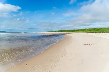 Berrak ve yoğun kum bulutlu mavi gökyüzüne karşı ve Brezilya 'nın Bahia kentindeki Guaibim plajında güçlü güneş..