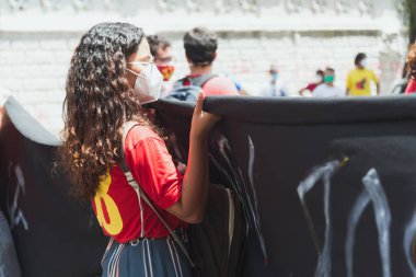 Salvador, Bahia, Brezilya - 02 Ekim 2021: Salvador kentinde Başkan Jair Bolsonaro 'ya karşı düzenlenen gösteri sırasında protestocu pankart taşıdı.