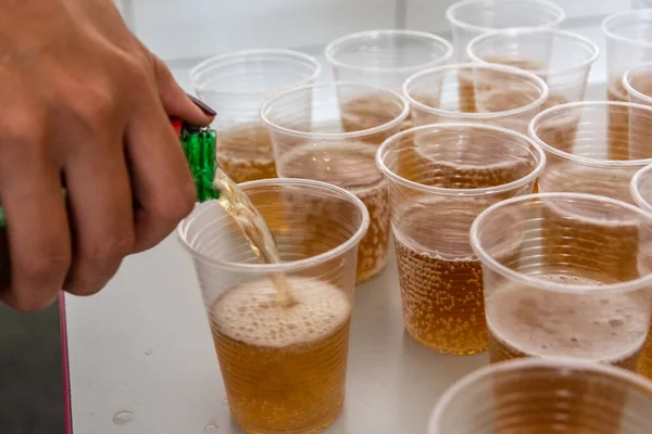 Soda being poured into a plastic cup to be drunk. Salvador, Bahia, Brazil.