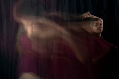 Bir bayanın paçavrayı hareket ettirdiğine dair anlık bir bakış açısı. Uzun pozlama, hareket bulanıklığı. Salvador, Bahia, Brezilya.