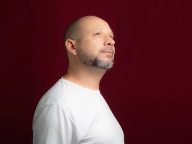 Kızıl arka plana bakan kel sakallı bir adamın portresi. Salvador, Bahia, Brezilya.