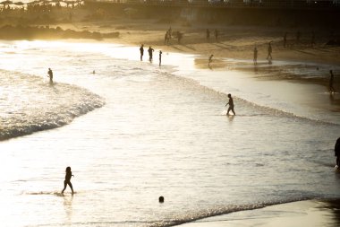 Salvador, Bahia, Brazil - November 01, 2021: People walking on the sand of Rio Vermelho beach in Salvador, Bahia, in the late afternoon.