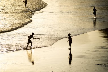 Salvador, Bahia, Brazil - November 01, 2021: People walking on the sand of Rio Vermelho beach in Salvador, Bahia, in the late afternoon.