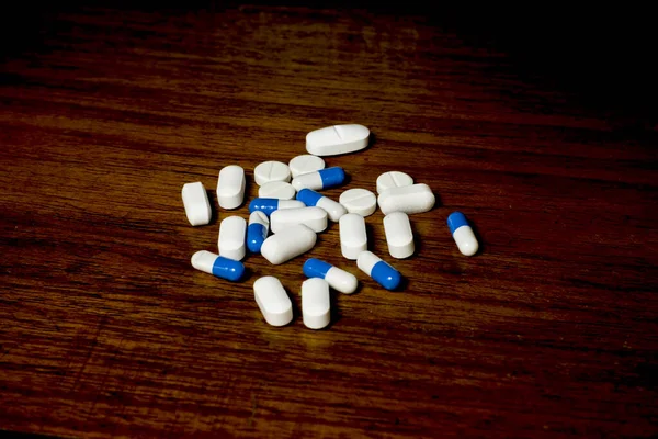 Jednoduchá Hromada Bílých Modrých Pilulek Léků Pilulek Navršených Hnědém Pozadí — Stock fotografie