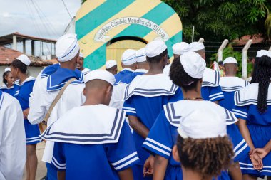 Men, women and children, members of the cultural group Chegana dos Marujos, dance and sing in costumes during a performance at the streets of Saubara, Bahia.
