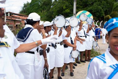 Men, women and children, members of the cultural group Chegana dos Marujos, dance and sing in costumes during a performance at the streets of Saubara, Bahia.