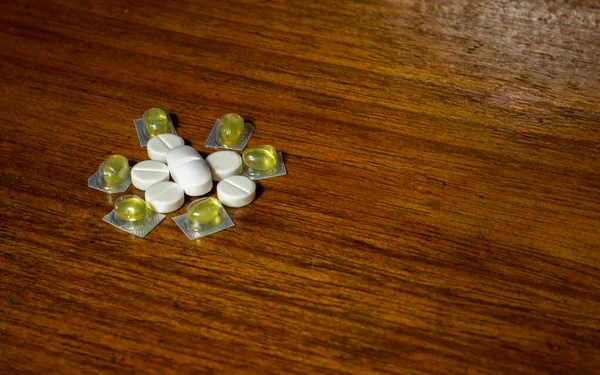 Jednoduchá Hromada Bílých Žlutých Pilulek Léků Pilulek Navršených Hnědém Pozadí — Stock fotografie