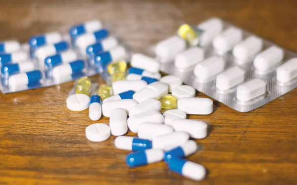 Simple Pile White Blue Yellow Pills Medicines Pills Stacked Brown — стоковое фото