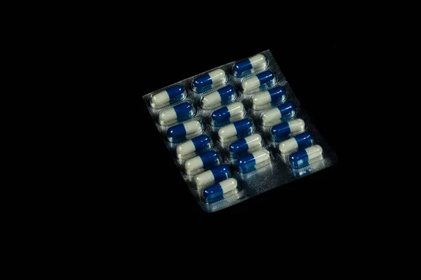 Een Pakje Blauwe Witte Pillen Een Zwarte Achtergrond — Stockfoto