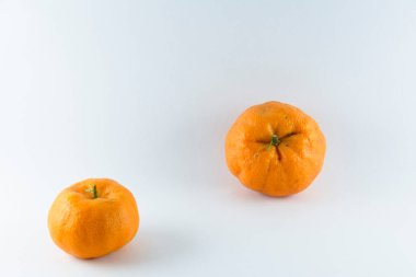 Surface covered with two ripe fresh juicy tangerines, composition isolated over the white background.