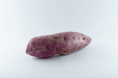 Surface covered with a ripe fresh sweet potato, composition isolated over the white background.