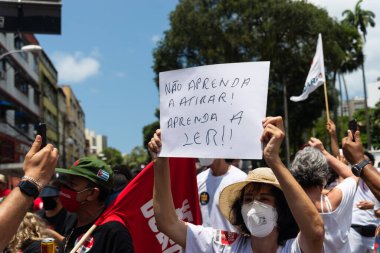 Salvador, Bahia, Brezilya - 02 Ekim 2021: Protestocu, Salvador kentinde Başkan Jair Bolsonaro 'ya karşı düzenlenen bir gösteri sırasında bir poster taşıdı..