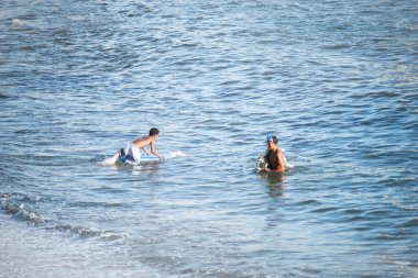 Salvador, Bahia, Brezilya - 01 Kasım 2021: Salvador, Bahia 'daki Rio Vermelho sahiline giren sörfçü.