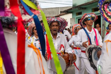 Saubara, Bahia, Brazil - August 06, 2022: Cultural demonstration called Encontro de Chegancas in Saubara, Bahia. Members of a Marujada wear white clothes with colors and play percussion musical instruments.