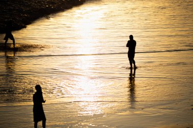 Salvador, Bahia, Brazil - November 01, 2021: People walking e se divertindo on the sand of Rio Vermelho beach in Salvador, Bahia, in the late afternoon.