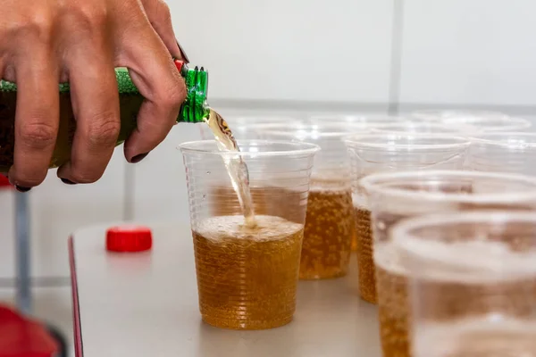 Soda being poured into a plastic cup to be drunk. Salvador, Bahia, Brazil.