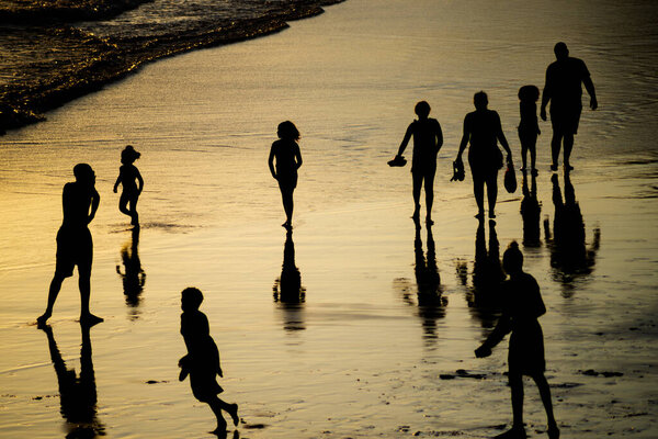 Salvador, Bahia, Brazil - November 01, 2021: People walking e se divertindo on the sand of Rio Vermelho beach in Salvador, Bahia, in the late afternoon.