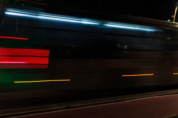 Colorful light trails with motion blur effect of a bus, long time exposure. Isolated in the foreground.