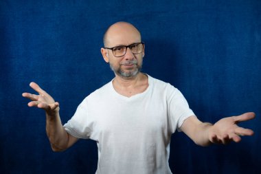 Portrait of a bearded bald man against blue background.