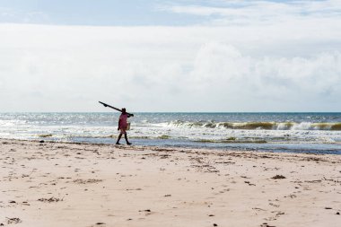 Fisherman is seen walking on the beach. Guaibim beach in the city of Valenca, Bahia, Brazil.