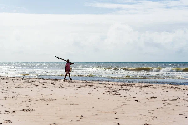 Fisherman is seen walking on the beach. Guaibim beach in the city of Valenca, Bahia, Brazil.
