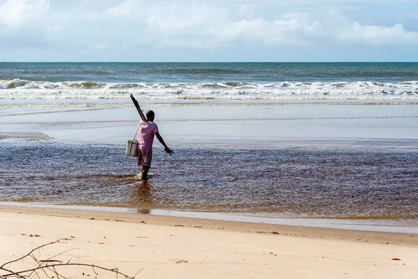Fisherman is seen walking on the beach. Guaibim beach in the city of Valenca, Bahia, Brazil.