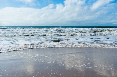 View of the beach sand against the sea and the beautiful blue sky with clouds. Guaibim beach in the city of Valenca, Bahia, Brazil.