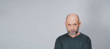 Portrait of mature man standing on white background. Serious bearded man. Formal style.