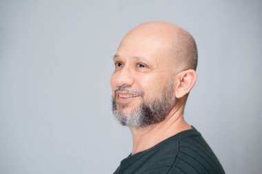 Portrait of mature man standing on light background. Bald bearded man. Formal style.