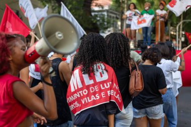 Salvador, Bahia, Brazil - April 09, 2022: Young people protesting against far-right presidential candidate Jair Bolsonaro, with megaphone posters and many screams.