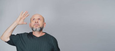Portrait of mature man standing on white background. Bald bearded man making gestures. Formal style.