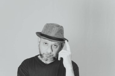 Portrait of mature man standing on white background. Bald bearded man in a brown hat. Formal style.