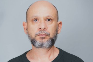 Portrait of mature man standing on white background. Serious bearded man. Formal style.