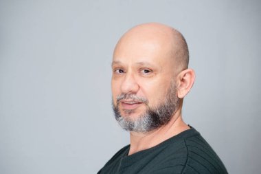 Portrait of mature man standing on light background. Bald bearded man. Formal style.
