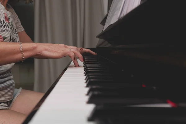 Beautiful Brazilian pianist woman touching piano keys, playing upright piano. Concept music teaching and arts. Relax and joyful.